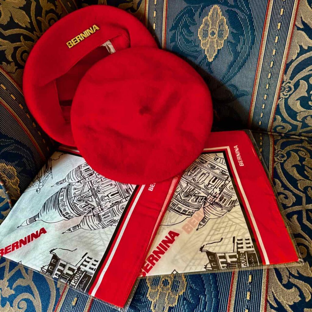 Two red BERNINA berets and two BERNINA silk scarves